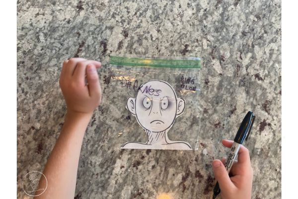 Harry Potter Defeat Voldemort Activity - There is a baggie with Voldemort's head from the printable taped on it. A child has written various fears on the baggie with permanent marker